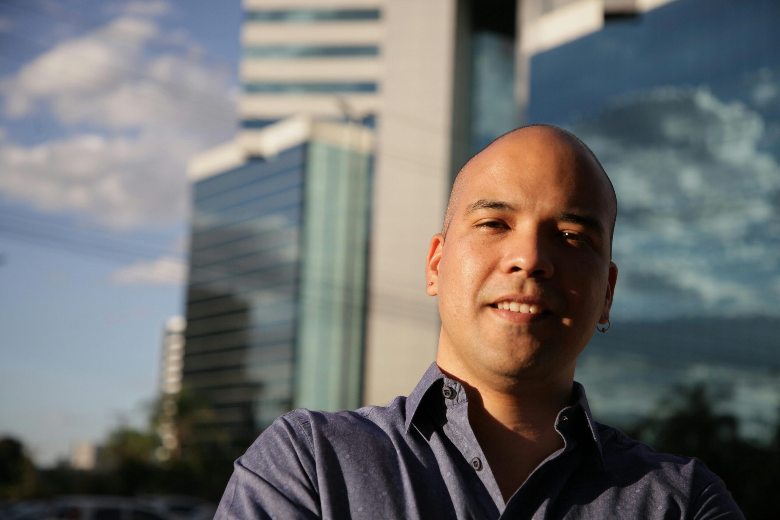 Home Smiling bald man in front of modern buildings in Brasília, Brazil.