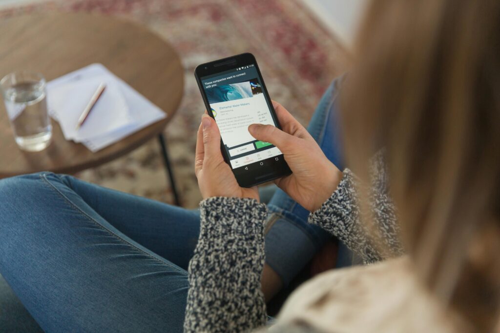 Home Close-up of woman using smartphone indoors, focused on a mobile app.