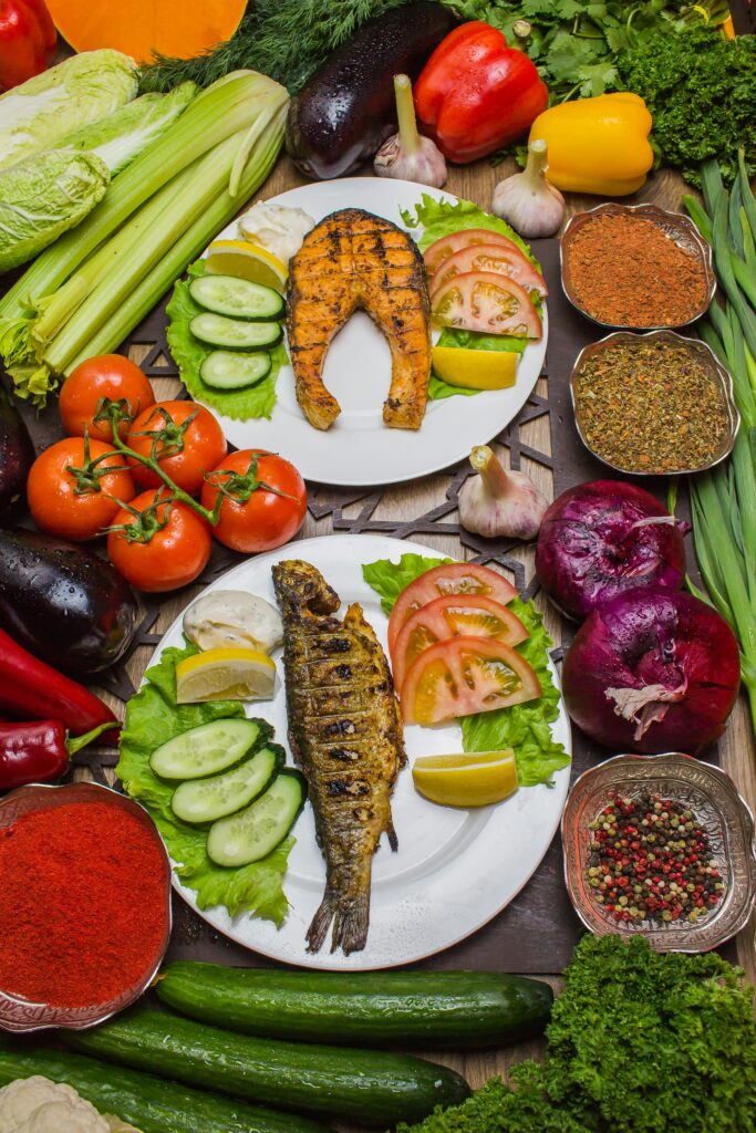 A colorful flat lay of grilled fish with fresh vegetables and spices.